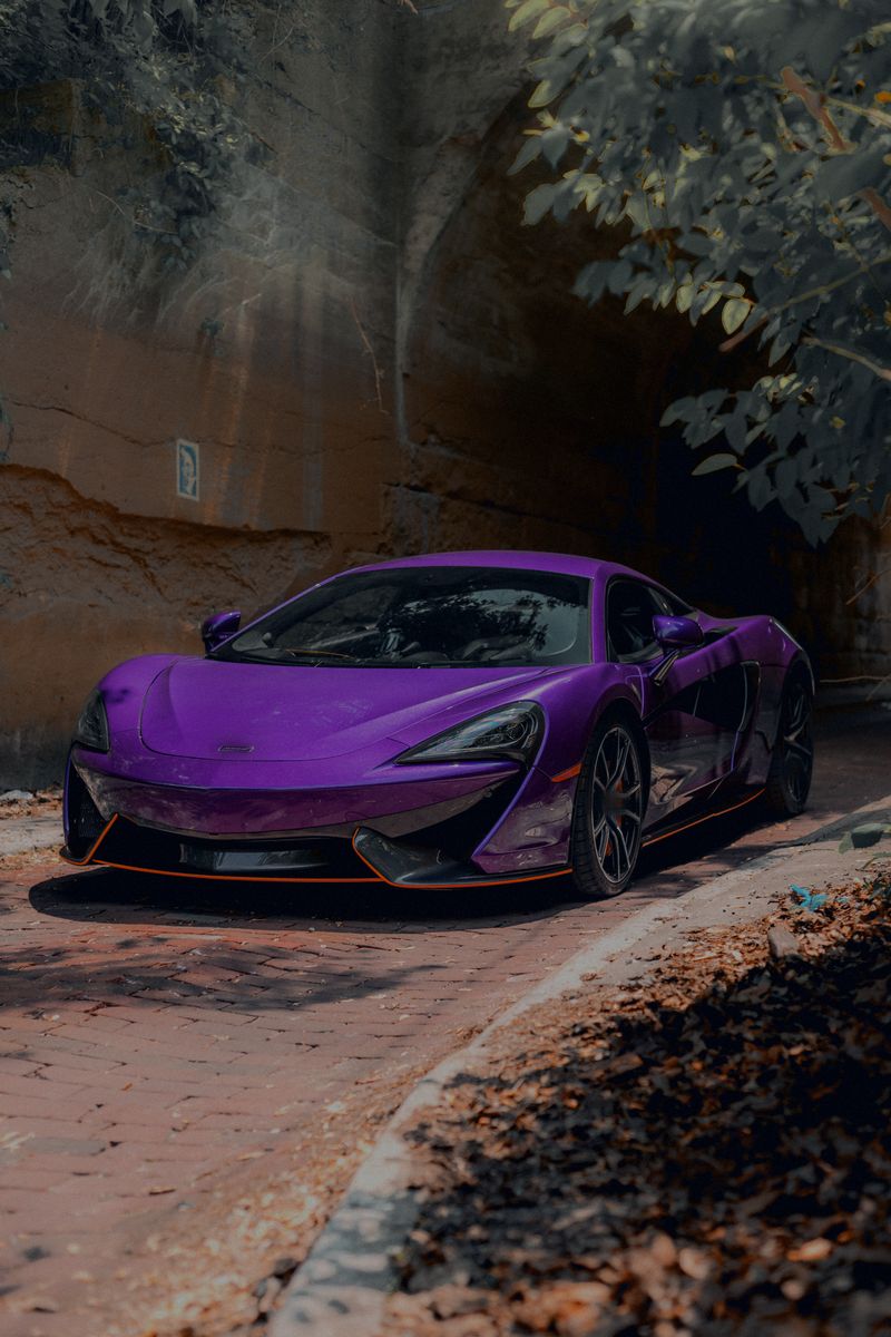 Front three-quarter view of the purple coupe beside a tunnel wall